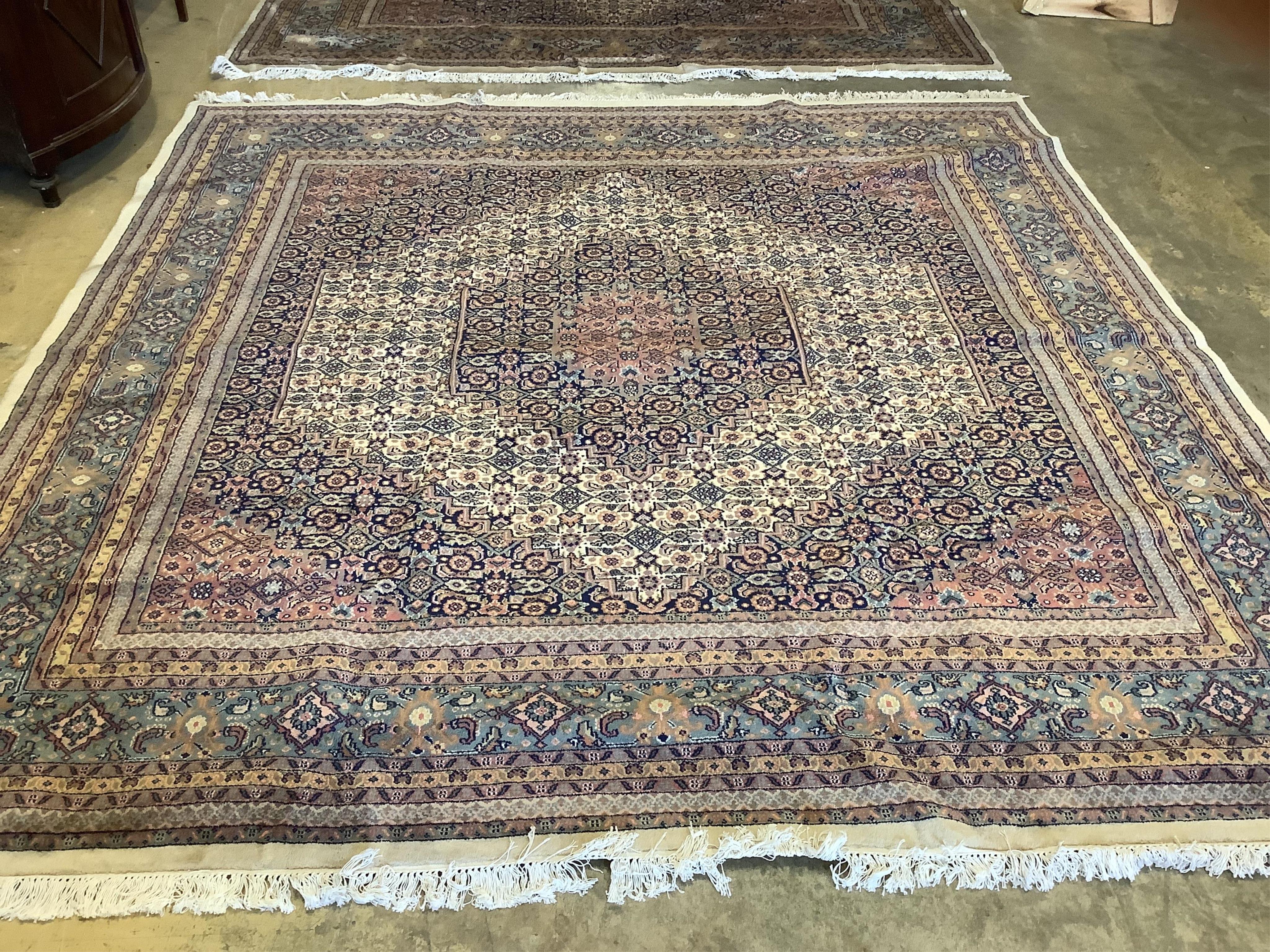 A pair of North West Persian ivory ground carpets, each 294 x 299cm. Condition - fair